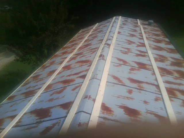 Rusted metal roof panels with new wood purlins before replacement — Storm Damage Roof Repair in Patchogue by Roofing Brothers
