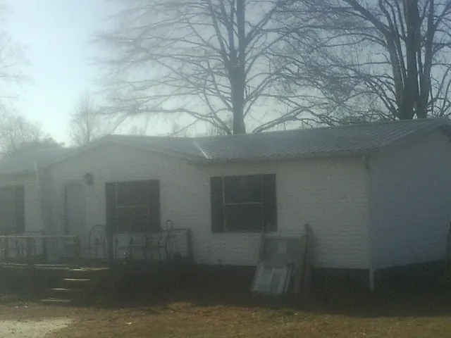 New metal roof on a white painted brick home on a foggy morning in Patchogue