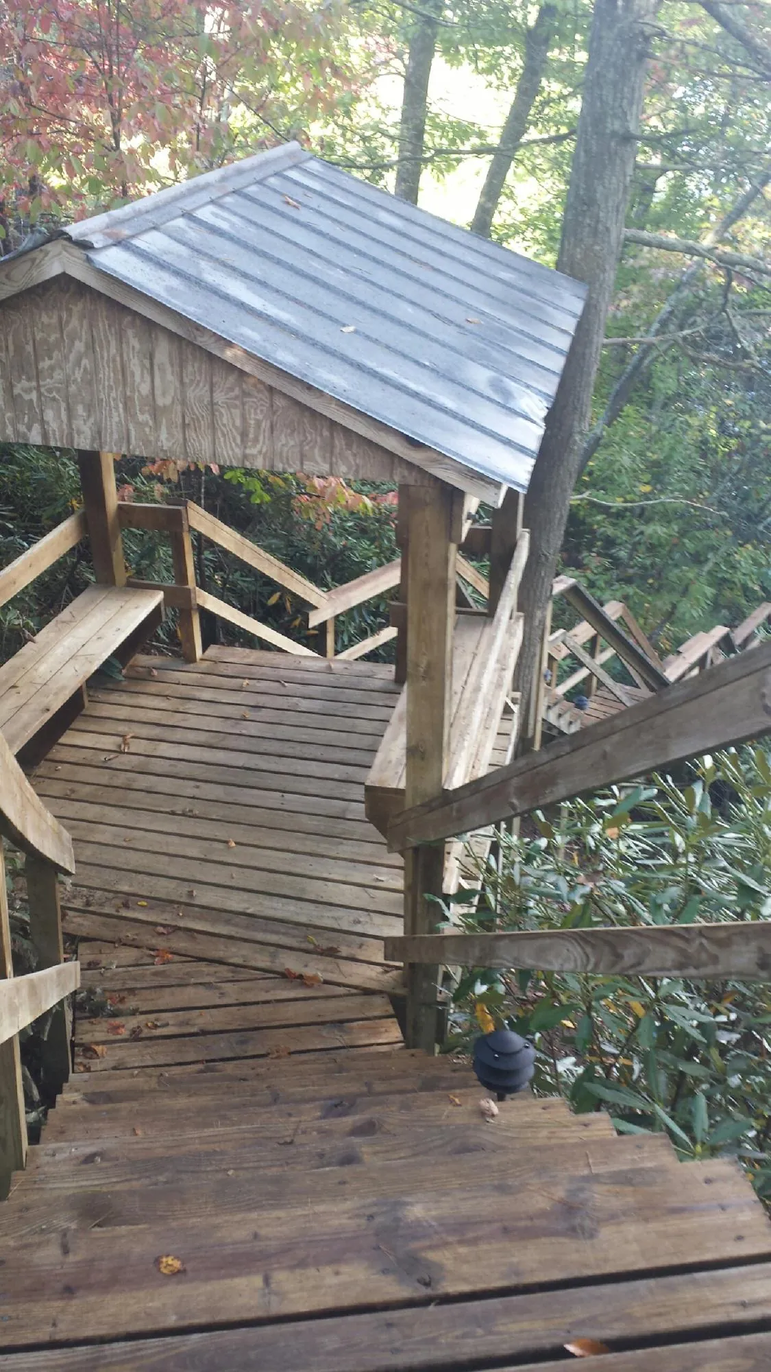 Metal roofed shelter over wooden steps on a wooded walkway — Skylight Repair & Installation work by our crew in Patchogue