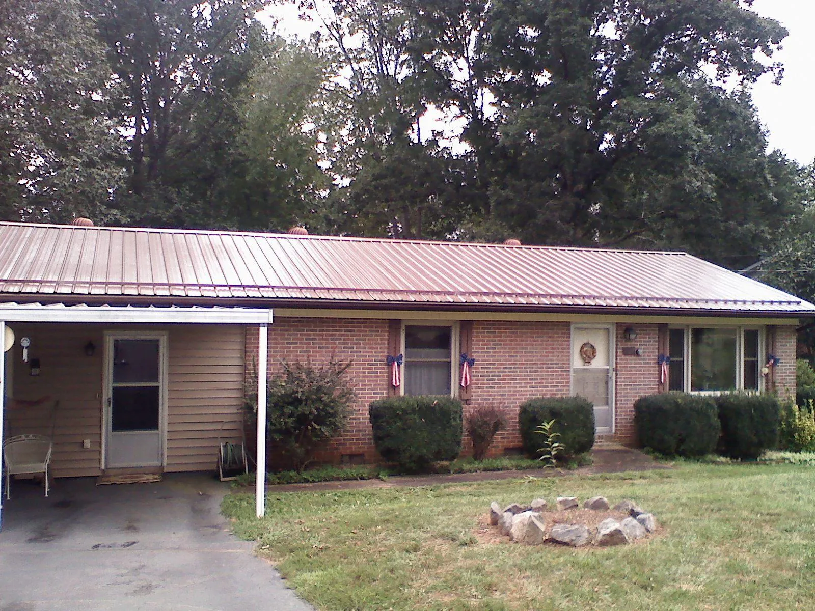 Bronze metal roof and carport on a brick ranch home — Roof Repair work by our crew in Patchogue